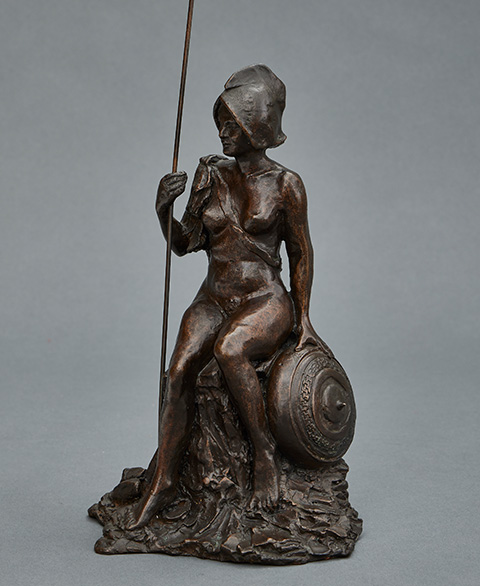 bronze sculpture of a seated woman holding a spear with a round shield beside her representing strength and resilience in art two themes two aspects